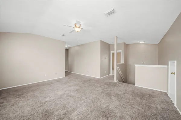 a view of an empty room with a ceiling fan
