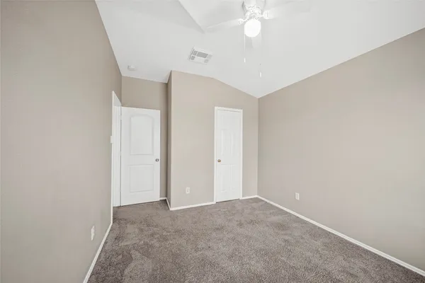a view of an empty room with a chandelier fan