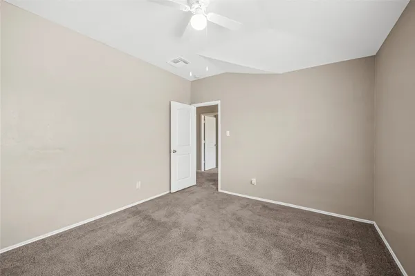 an empty room with a ceiling fan and a window