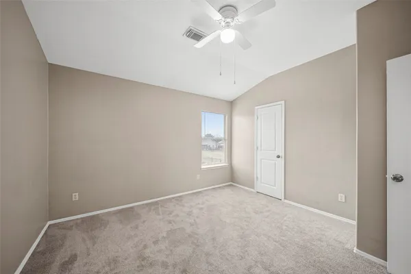 an empty room with a ceiling fan and a window