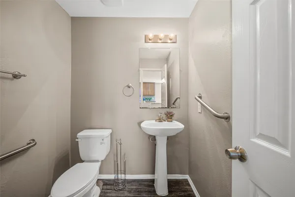 a bathroom with a toilet sink and mirror