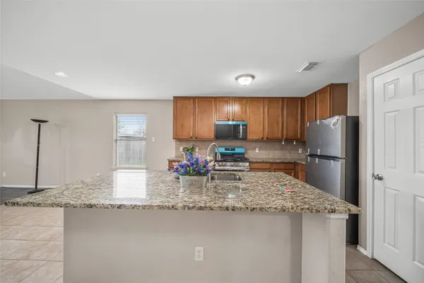a kitchen with stainless steel appliances granite countertop a sink refrigerator and cabinets