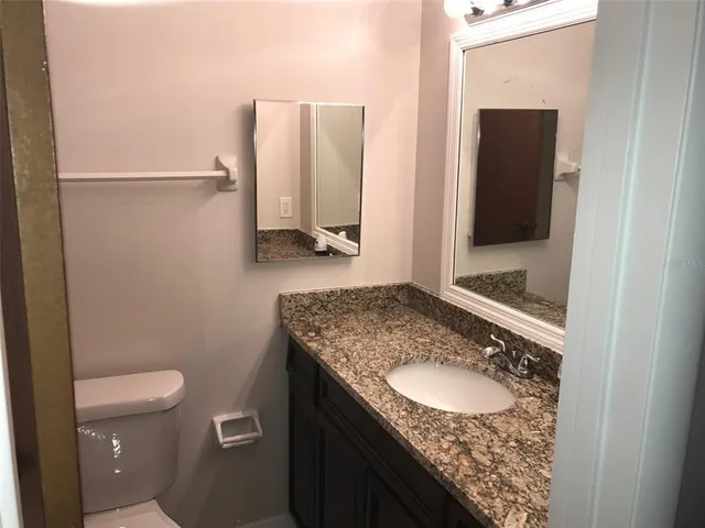 a bathroom with a granite countertop sink and a mirror