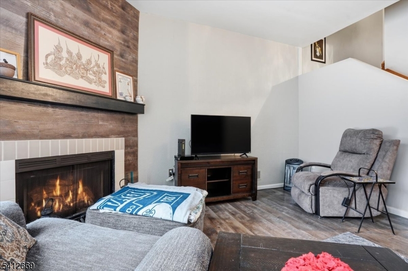 76 Hickory Way Mount Arlington, NJ 07856 - Photo 7 of 25 a living room with furniture a flat screen tv and a fireplace