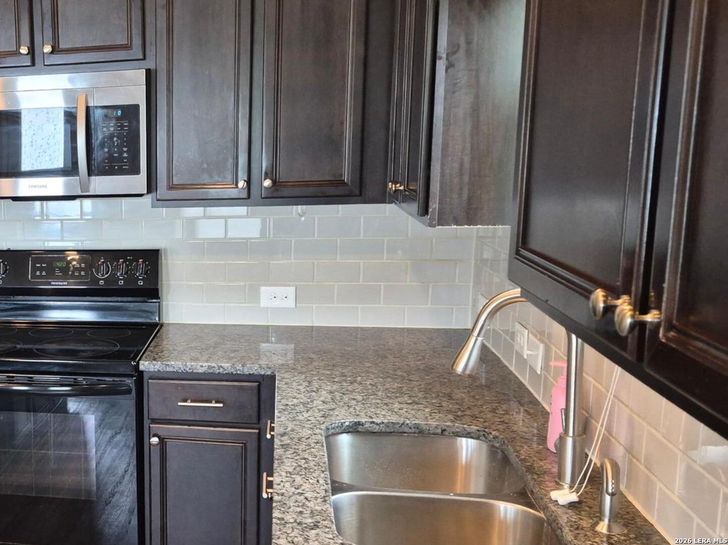 7102 Zuma Beach Converse, TX 78109 - Photo 10 of 31 a kitchen with granite countertop a sink and a refrigerator