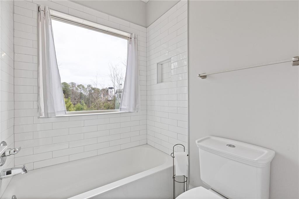 1560 Tapestry Ridge Southeast Lawrenceville, GA 30045 - Photo 24 of 57 a bathroom with a toilet a bath tub and a shower