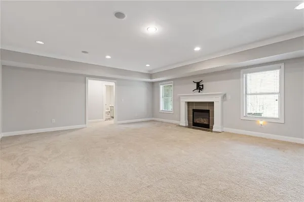a view of an empty room with a fireplace and a window