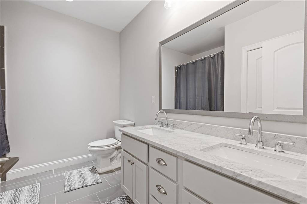1560 Tapestry Ridge Southeast Lawrenceville, GA 30045 - Photo 50 of 57 a bathroom with a granite countertop sink and a mirror