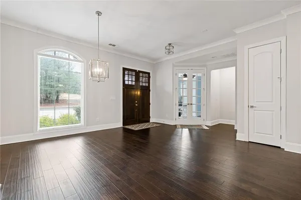 a living room with furniture a wooden floor and a chandelier