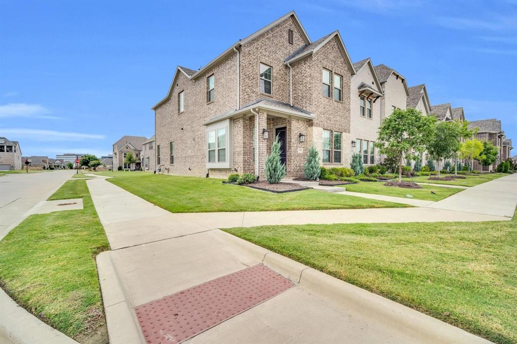 1498 Weston Road Dallas, TX 75234 - Photo 2 of 24 Brick facade with gabled roofline, featuring a covered entryway with decorative lighting, a bay window, and a concrete walkway
