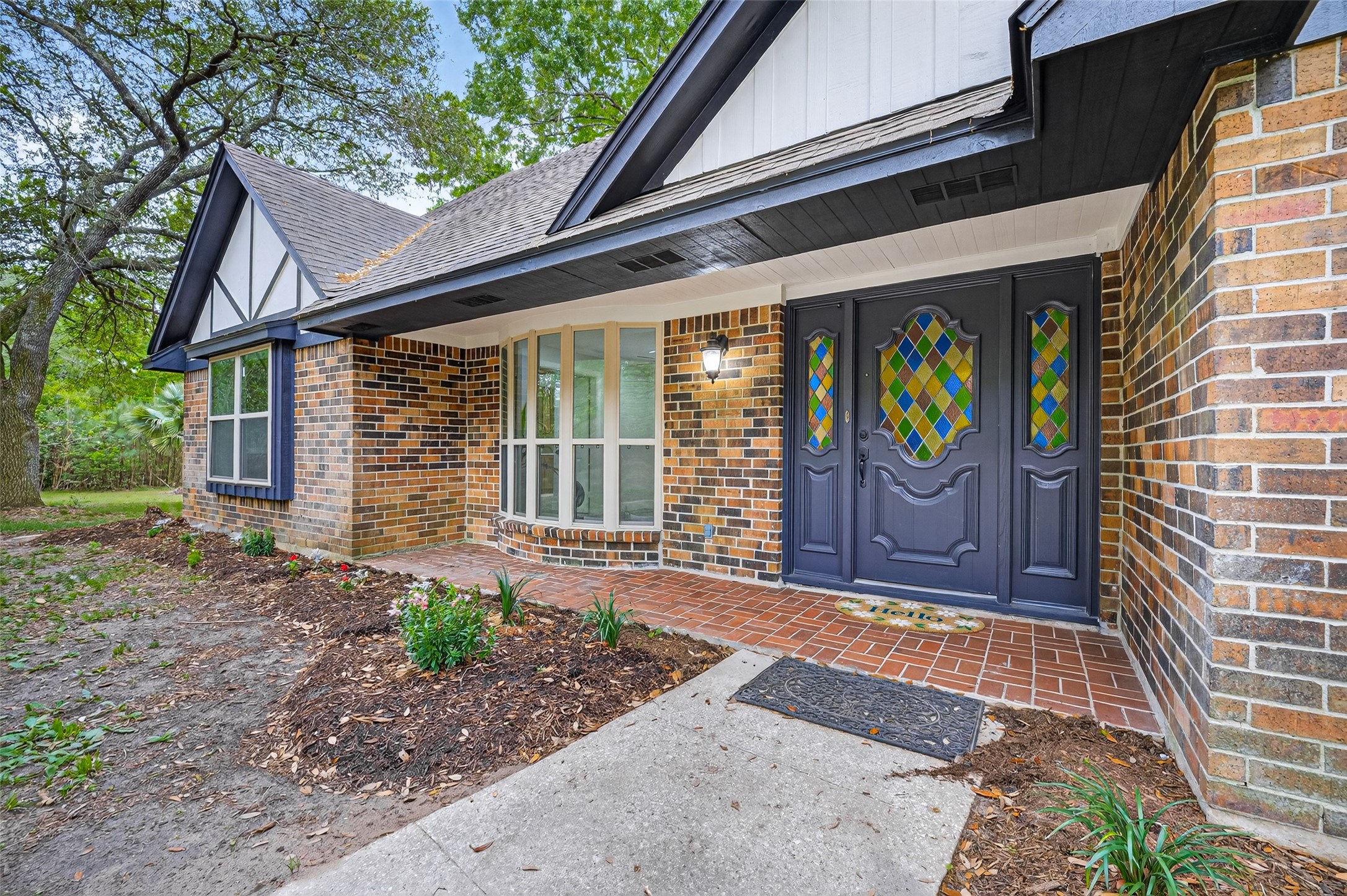 23607 Cardinal Drive Hockley, TX 77447 - Photo 4 of 50 The brick facade is punctuated by a stunning front door featuring stained glass accents, illuminated by a classic sconce that beckons guests onto the sheltered porch.