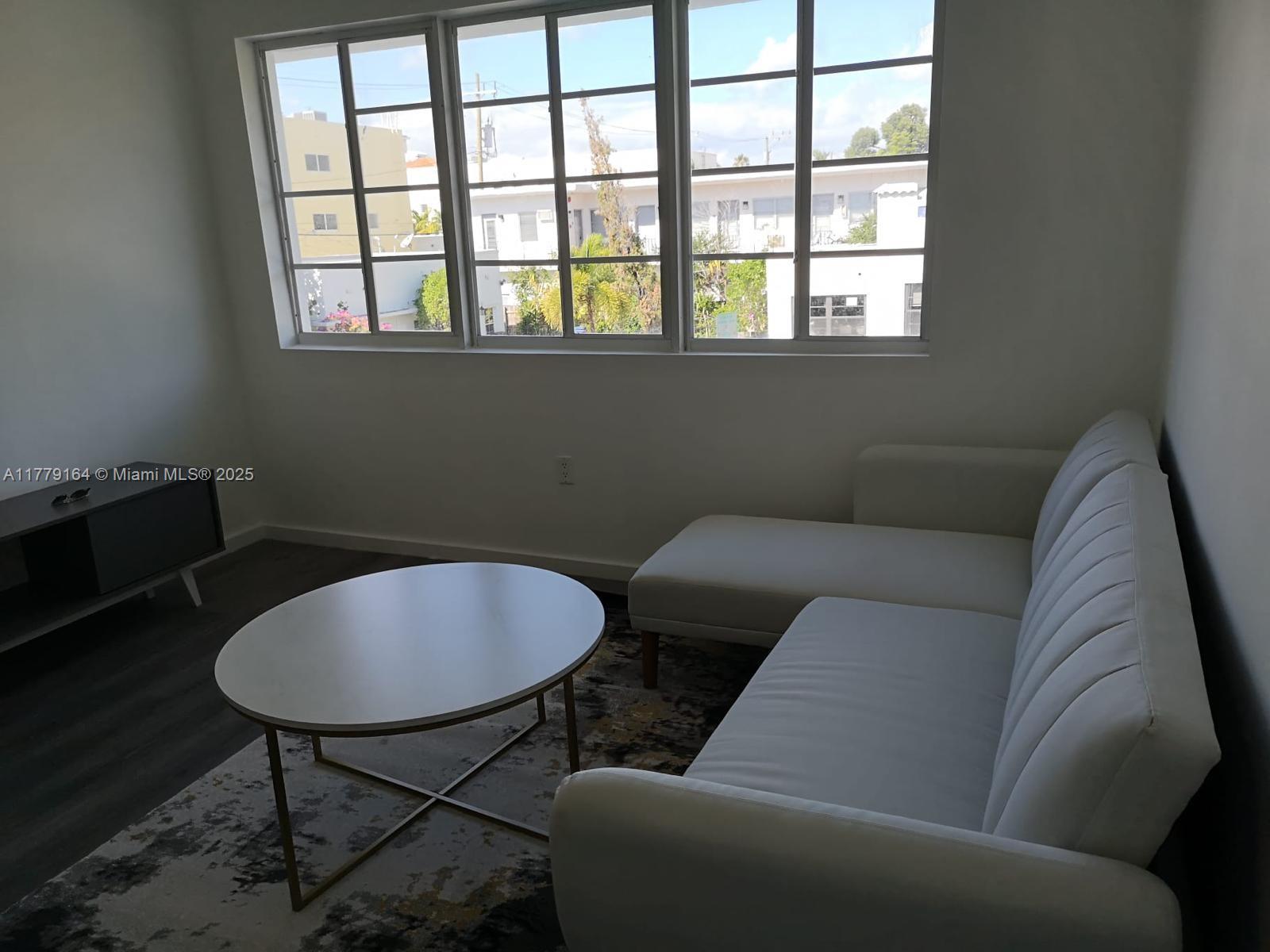 810 7th Street, Unit 203 Miami Beach, FL 33139 - Photo 3 of 7 a living room with furniture and a window