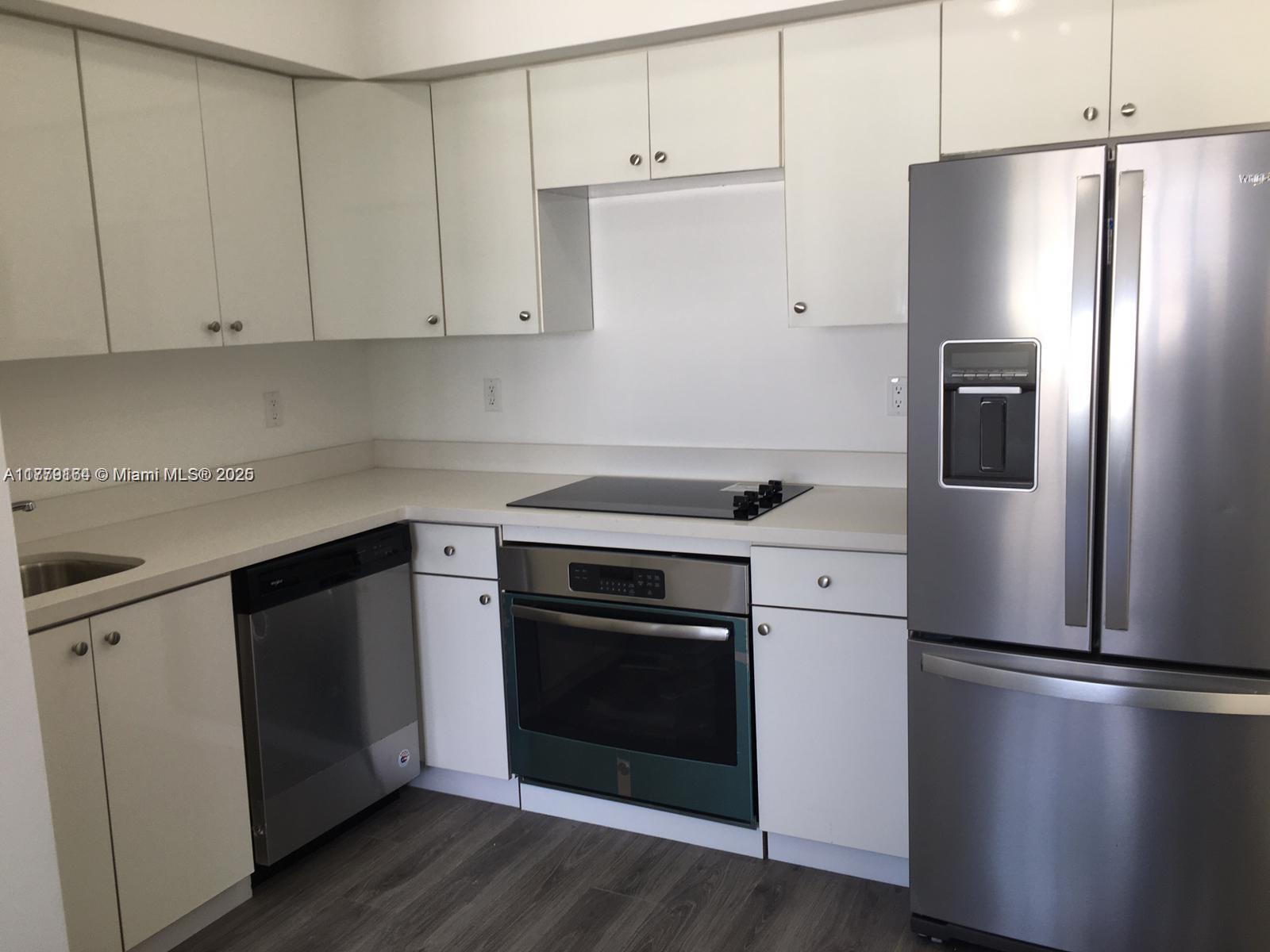 810 7th Street, Unit 203 Miami Beach, FL 33139 - Photo 4 of 7 a kitchen with a refrigerator stove and white cabinets