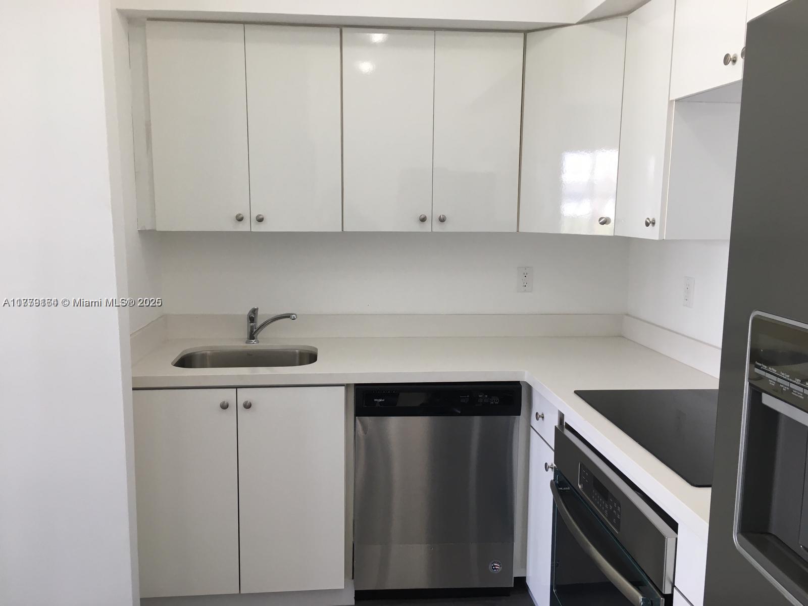 810 7th Street, Unit 203 Miami Beach, FL 33139 - Photo 5 of 7 a kitchen with a sink cabinets and stainless steel appliances