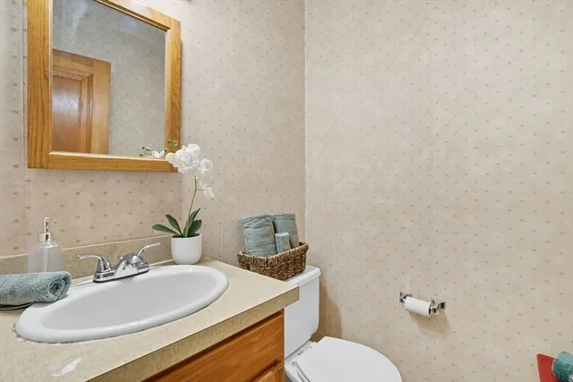 a bathroom with a granite countertop sink mirror and toilet