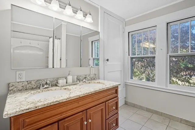 a bathroom with a granite countertop sink a mirror and a bathtub