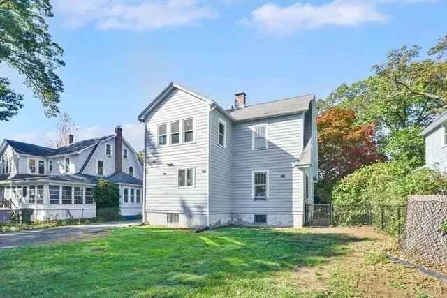 a front view of a house with a garden and tree