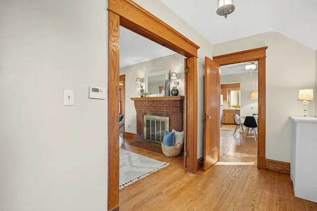 a view of a livingroom with wooden floor and a fireplace