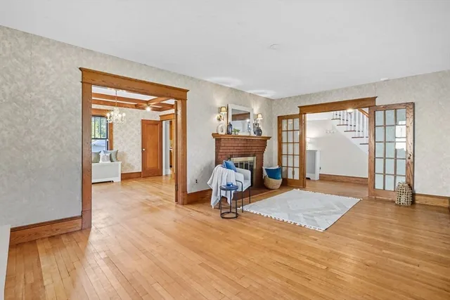 a view of a livingroom with wooden floor and a fireplace