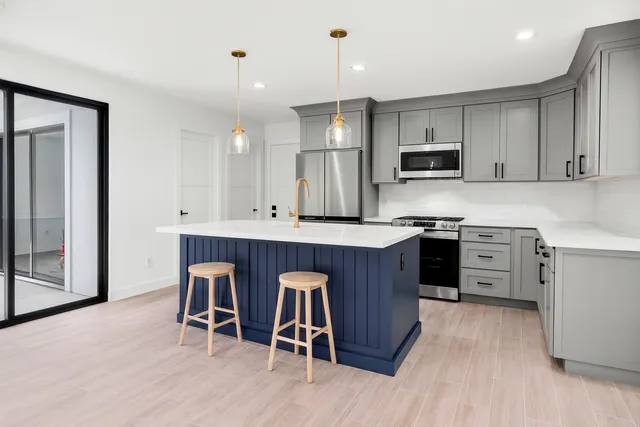 a kitchen with a sink cabinets and wooden floor