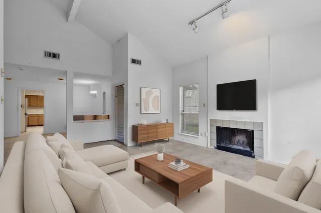 a living room with furniture a fireplace and a flat screen tv