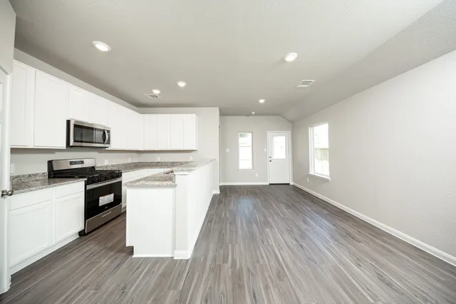 a kitchen with stainless steel appliances granite countertop a stove a sink and a refrigerator