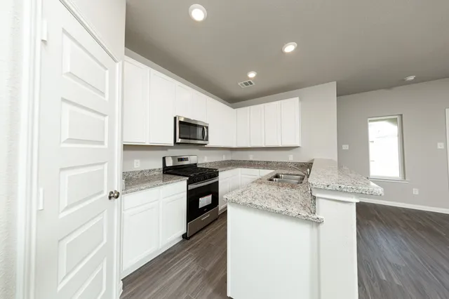 a kitchen with granite countertop white cabinets and white appliances