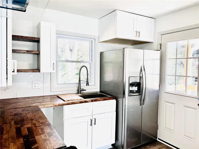a kitchen with stainless steel appliances granite countertop a refrigerator and a stove