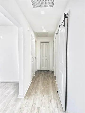a view of a hallway with wooden floor and entryway