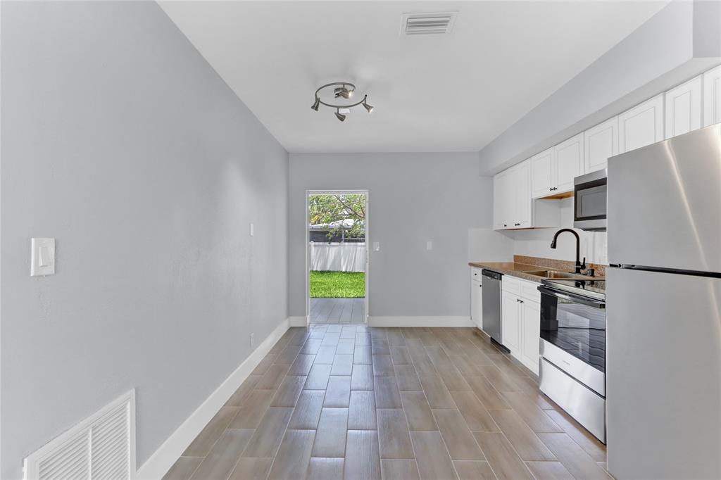 2822 North Dixie Highway Boca Raton, FL 33431 - Photo 3 of 22 a kitchen with granite countertop a refrigerator and a stove top oven