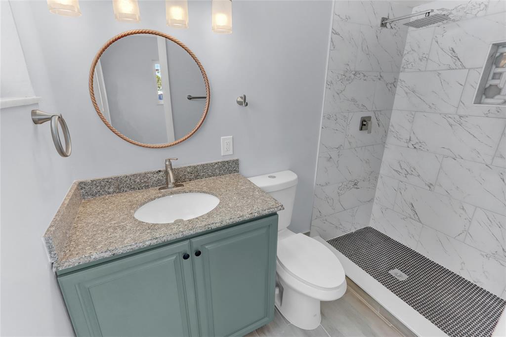 2822 North Dixie Highway Boca Raton, FL 33431 - Photo 8 of 22 a bathroom with a granite countertop toilet a sink and a mirror