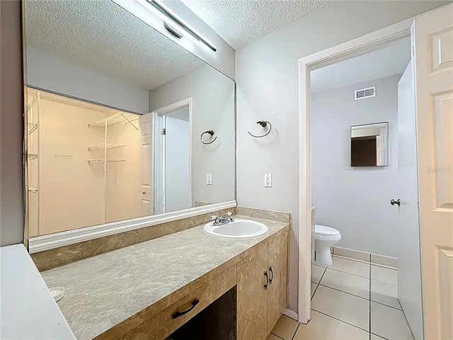 a bathroom with a sink vanity mirror and toilet