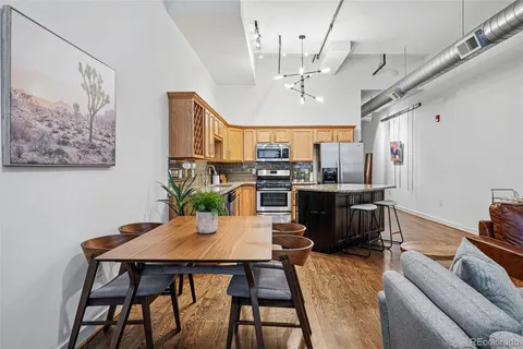 a view of a dining room with furniture a kitchen and chandelier