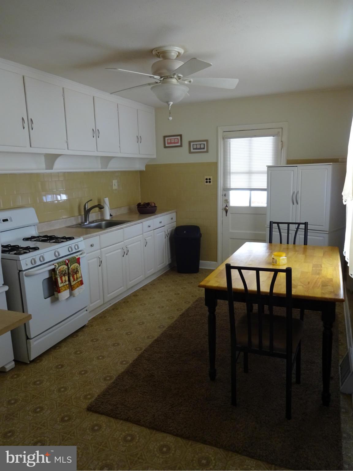 911 Woodlynn Road Baltimore, MD 21221 - Photo 4 of 10 a kitchen with a table chairs stove and cabinets