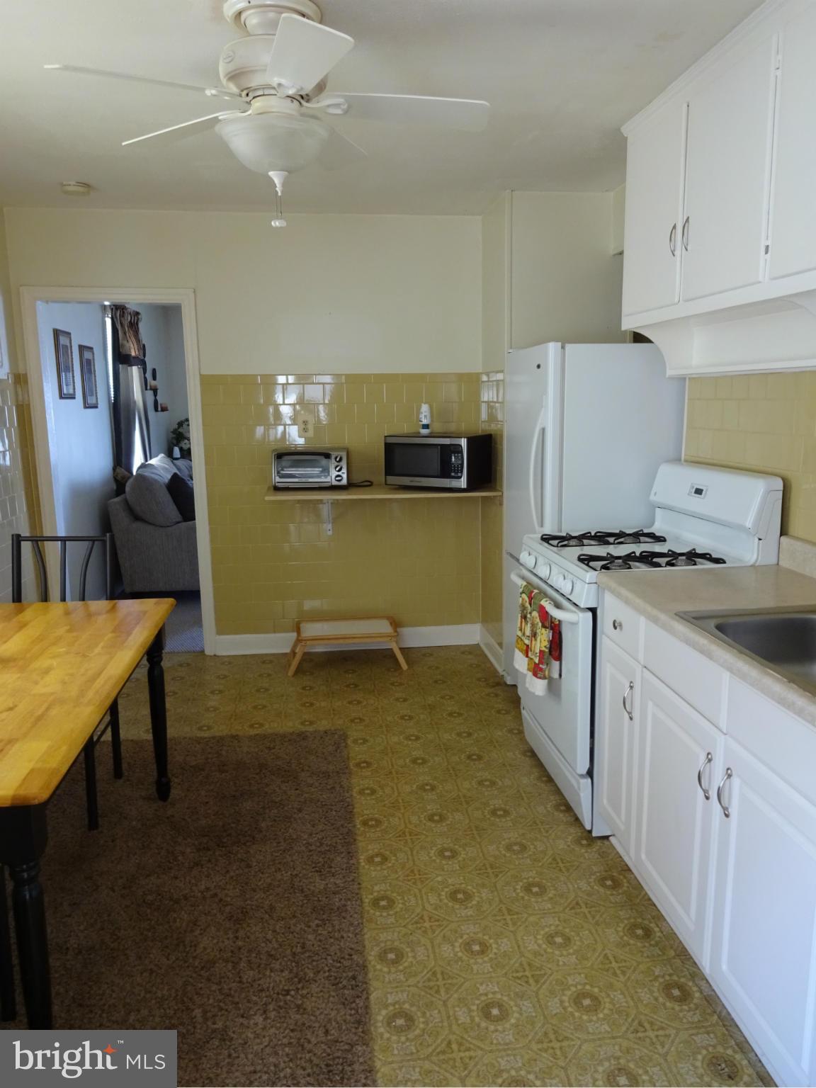 911 Woodlynn Road Baltimore, MD 21221 - Photo 5 of 10 a kitchen with kitchen island a stove a sink dishwasher and a refrigerator with wooden floor
