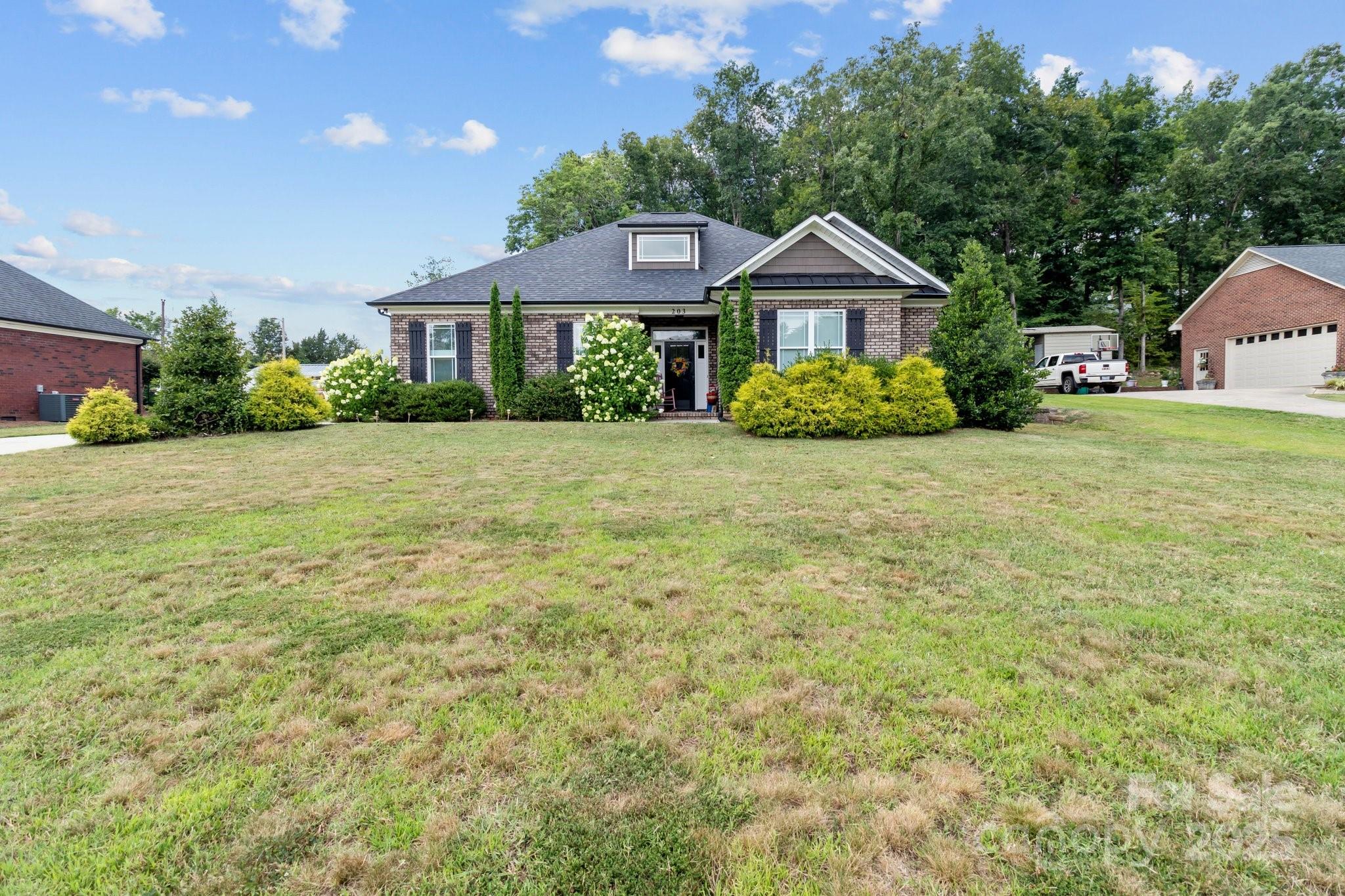 a front of a house with a yard and trees