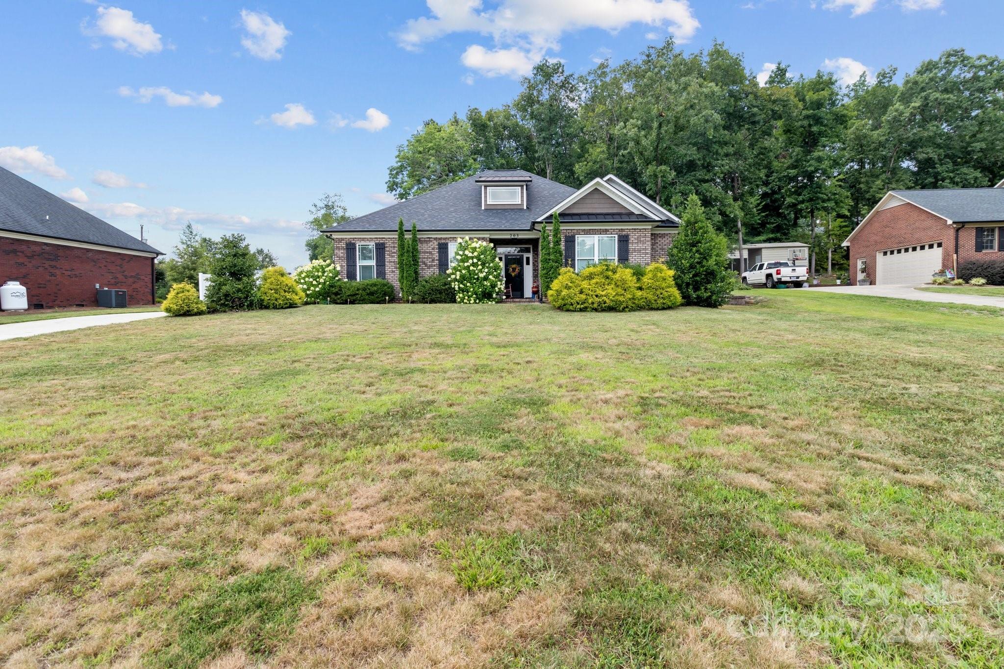 203 Poplins Grove Church Road Albemarle, NC 28001 - Photo 17 of 48 a front view of house with yard and trees in the background
