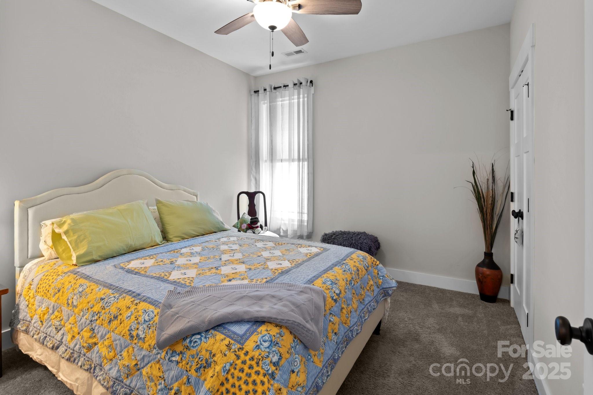 203 Poplins Grove Church Road Albemarle, NC 28001 - Photo 29 of 48 a bedroom with a bed and a chandelier