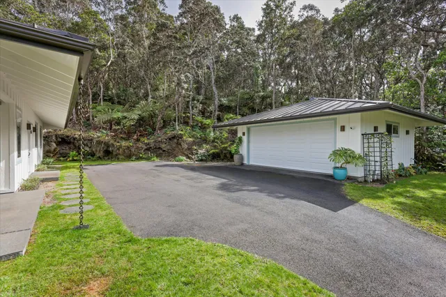 a front view of a house with garden and sitting area
