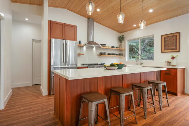 a kitchen with stainless steel appliances a dining table chairs and wooden floor