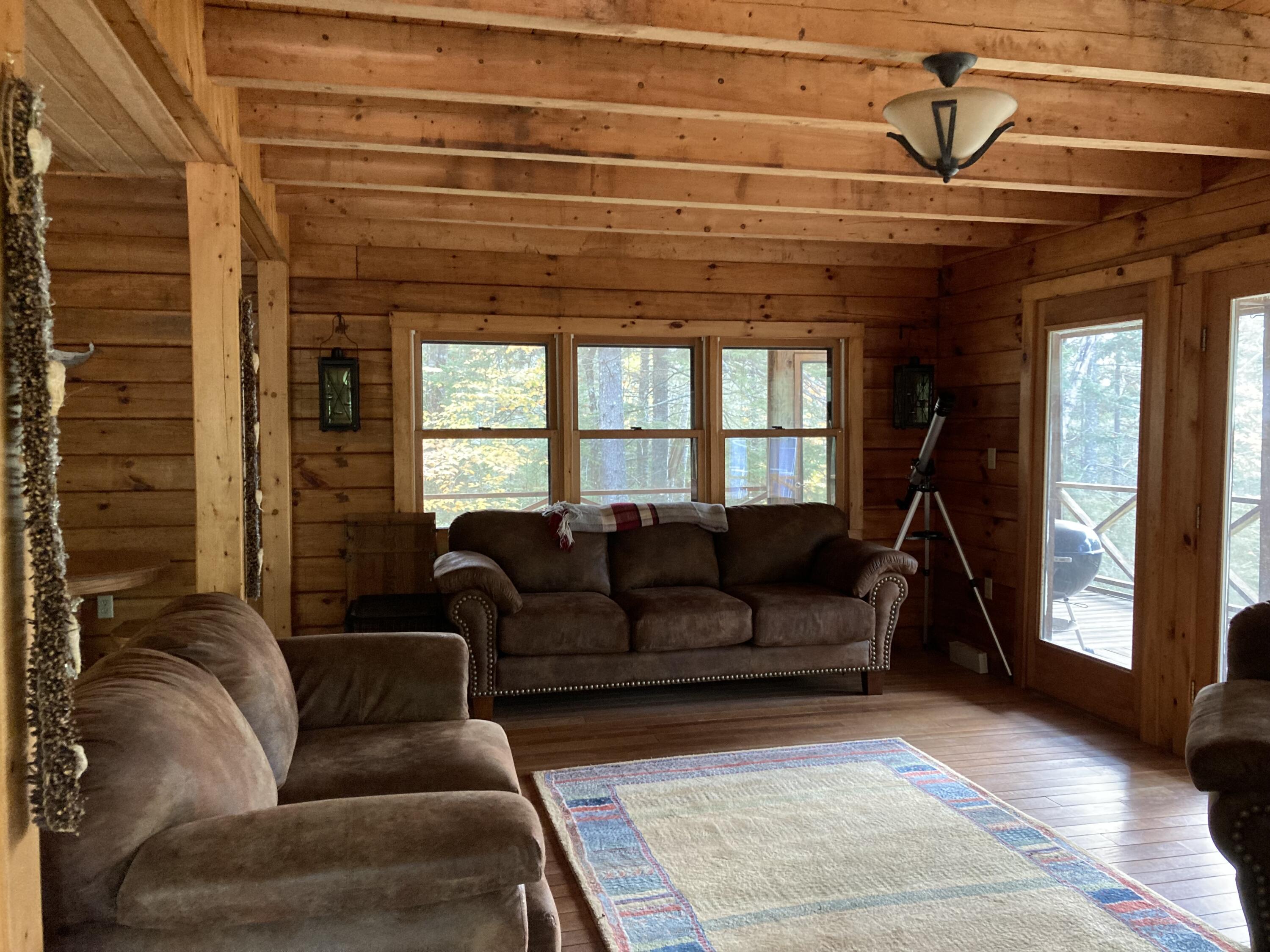 414 River Bend Cherryfield, ME 04622 - Photo 10 of 38 Living room w/slider to porch on water.