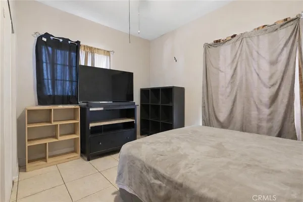a bedroom with a bed and a television