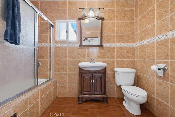 a bathroom with a toilet a sink and mirror