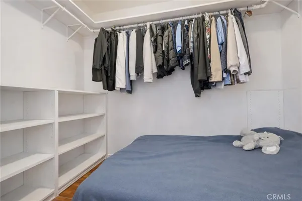 a view of walk in closet with clothes and shoes