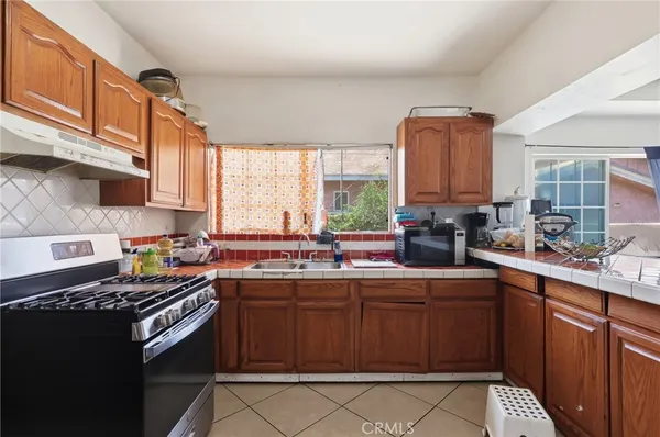 a kitchen with stainless steel appliances a sink stove and cabinets