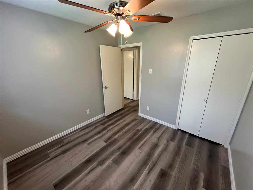 1413 Ridgecrest Drive Plano, TX 75074 - Photo 19 of 22 Unfurnished bedroom featuring dark wood-style floors, a ceiling fan, and a closet