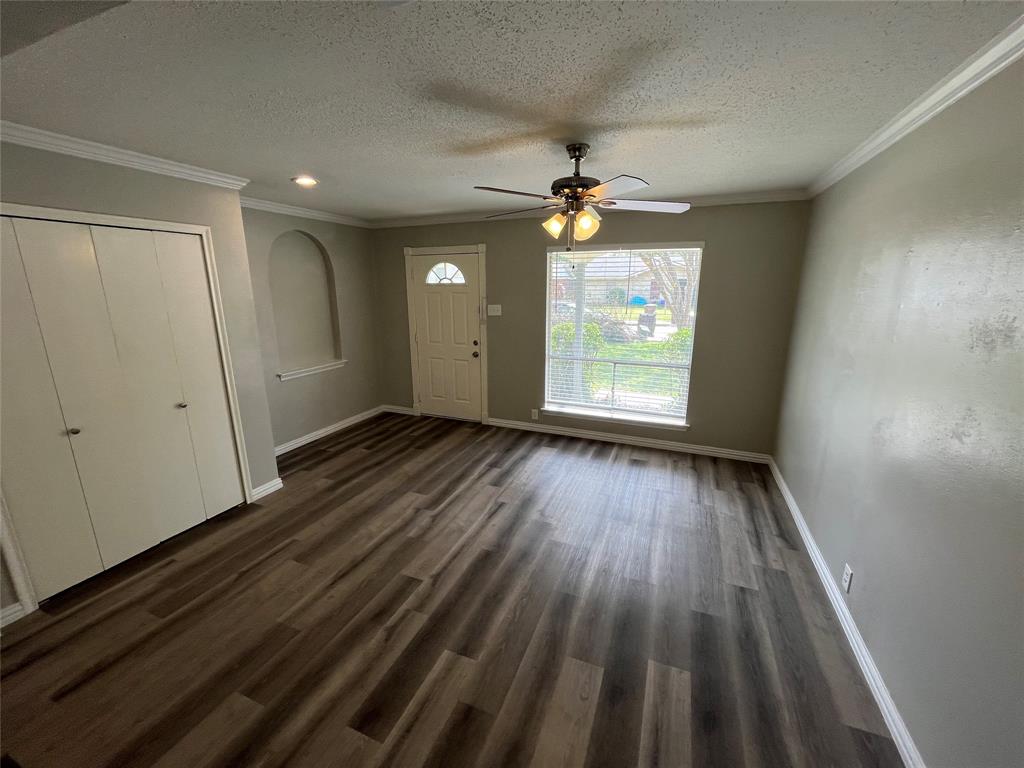 1413 Ridgecrest Drive Plano, TX 75074 - Photo 5 of 22 Entrance foyer featuring ceiling fan, ornamental molding, dark wood finished floors, and a textured ceiling