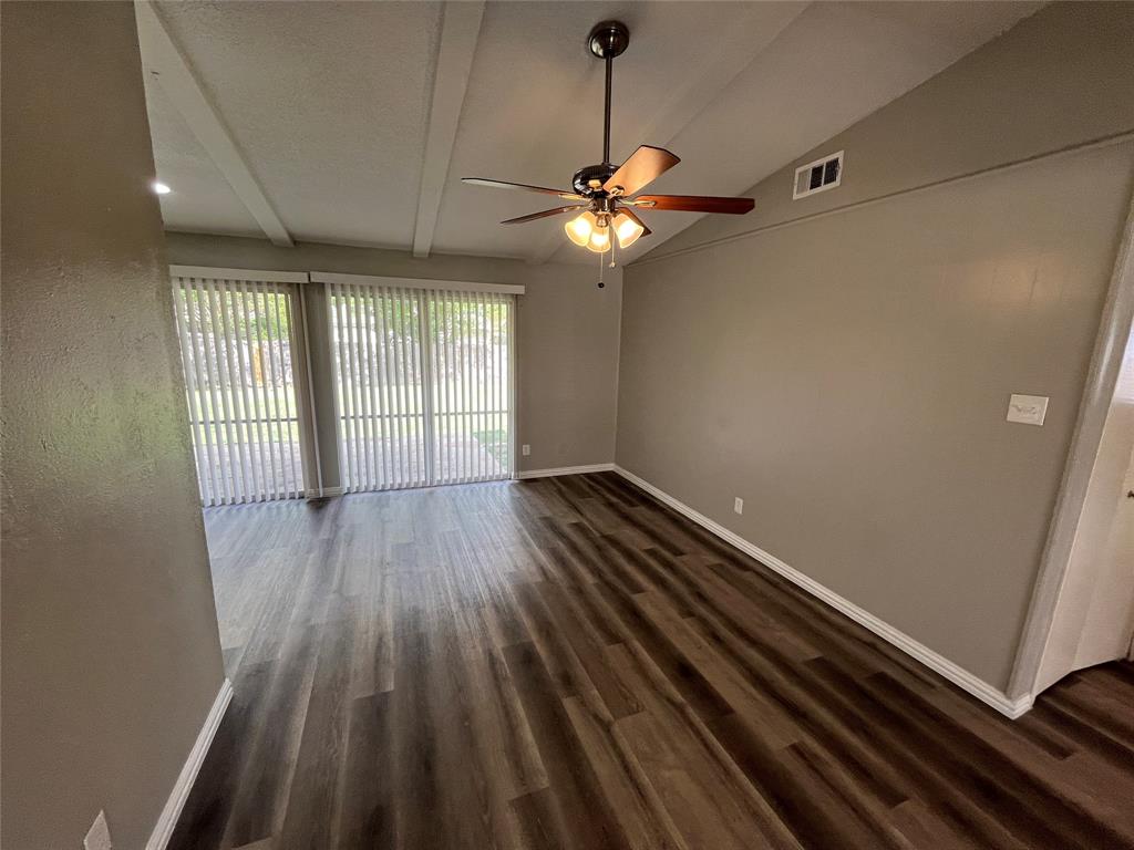 1413 Ridgecrest Drive Plano, TX 75074 - Photo 6 of 22 Unfurnished room with a ceiling fan, dark wood-style floors, and vaulted ceiling with beams