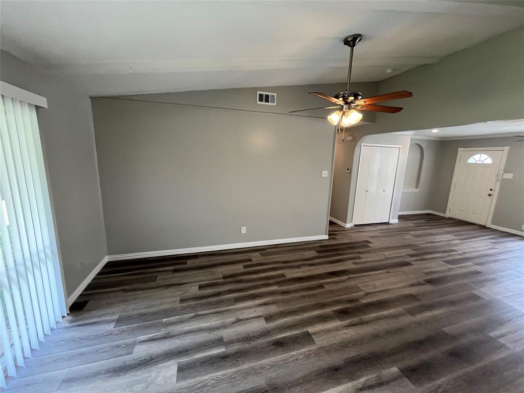 1413 Ridgecrest Drive Plano, TX 75074 - Photo 7 of 22 Unfurnished living room featuring lofted ceiling, arched walkways, ceiling fan, and dark wood-style floors