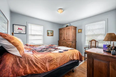 a bedroom with a bed and dresser with window